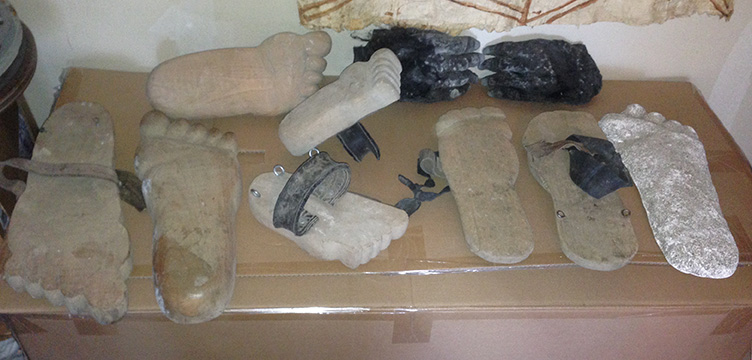 Collection of large wooden feet with shoe buckles.